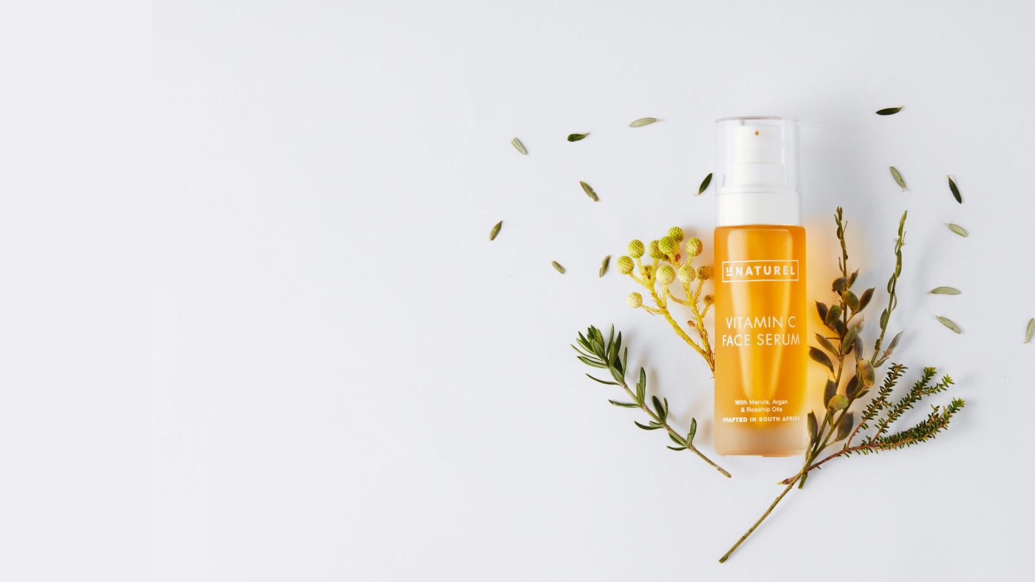 Skincare serum bottle with natural elements on a light background